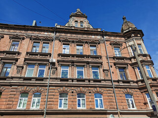 Fototapeta na wymiar The facade of an old residential building on one of the streets of Vyborg on a sunny summer day.