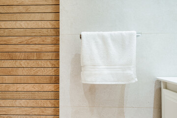 Modern bright bathroom interior with white towel and wooden effect tiles