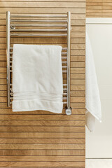 Modern bathroom interior with heated towel rail and wooden trim - 444213166