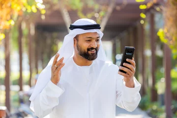 Foto op Canvas Middle Eastern Arab Emirati Vlogger holding mobile phone © Firoze
