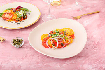 Plates with tasty tomato carpaccio and capers on color background
