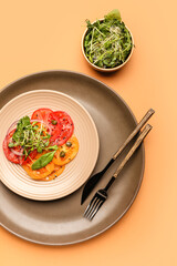 Plate with tasty tomato carpaccio and fresh sprouts on color background