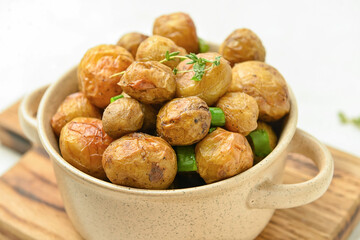 Pot with tasty baked potato on table, closeup