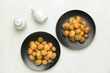 Plates with tasty baked potato on light background