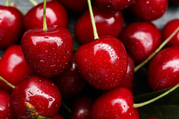 Tasty ripe cherries with water drops as background, closeup