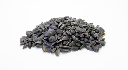 A heap of sunflower black seeds with shell on white background. Agriculture harvest time. Source for vegetable oil production.