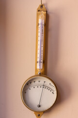 Isolated vintage temperature, pressure and humidity meter on beige background