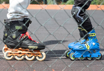 Lower body parts of adult and child riding on inline skates