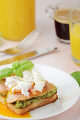 Breakfast with a sandwich with poached egg and avocado