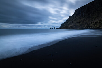Stormy morning at the shore of lonely Reynisfjara black sand beach near Vik i Myrdal looking to Reynisdrangar cliff in Iceland