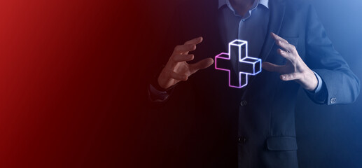 Businessman hold 3D plus icon, man hold in hand offer positive thing such as profit, benefits, development, CSR represented by plus sign.The hand shows the plus sign