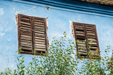 old painted adobe house facade with wooden shutters in Transylvania, Romania, East Europe