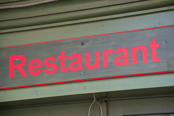 Closeup of restaurant sign on building facade in the street