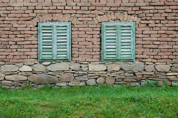 old brick and stone house facade with green wooden shutters in Transylvania, Romania, East Europe