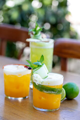 different type of summer fruit  cocktail with fresh limes on wooden table in a restaurant