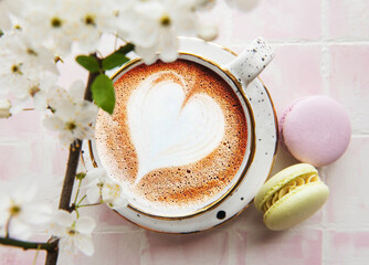 Coffee with a heart-shaped pattern and sweet macaroons desserts