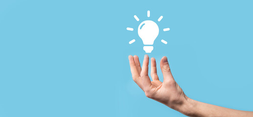 Hand hold light bulb. Holds a glowing idea icon in his hand. With a place for text.The concept of...