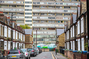 Traditional English terraced houses with huge council block Taplow House of the Aylesbury Estate in...