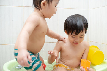Obraz na płótnie Canvas two little boys take a bath and play together