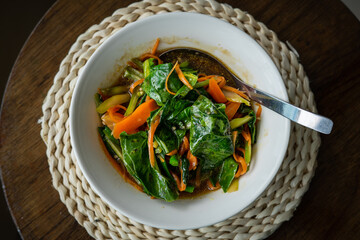 Chinese kale fried in oyster sauce and served in a bowl on the table.