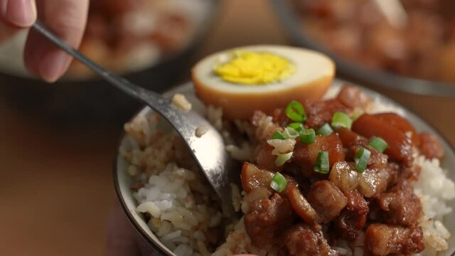 Eating braised meat over cooked rice, famous and delicious street food in Taiwan.