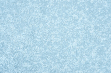 Icy light blue background with a beautiful frozen textured pattern with white luminous patches of the pattern