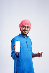 Young indian farmer showing card and smartphone on white background.
