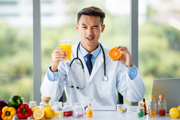 Asian nutritionist showing orange and juice