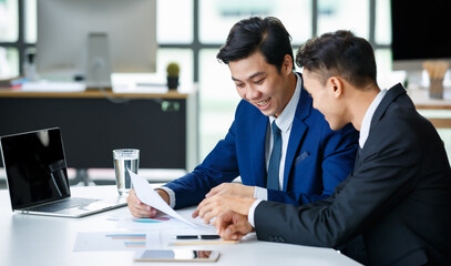 Cheerful businessmen reading documents in workplace