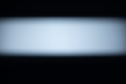 Beam from a white light source on black background, lens flare