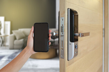 Hand holding smart phone to Open digital door locking system by Mobile application.