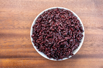 Obraz na płótnie Canvas Healthy Riceberry Rice In a bowl on wooden Background.