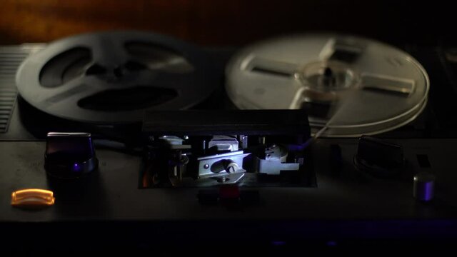 Playing a magnetic tape in a reel to reel tape recorder.