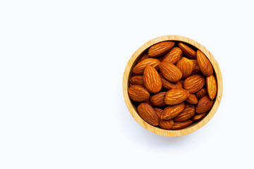 Almonds in wooden bowl on white background.