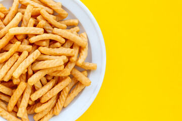 Prawn cracker sticks on yellow background. Shrimp crisp rice snack