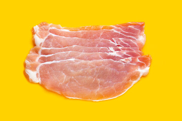 Sliced raw pork meat on yellow background.