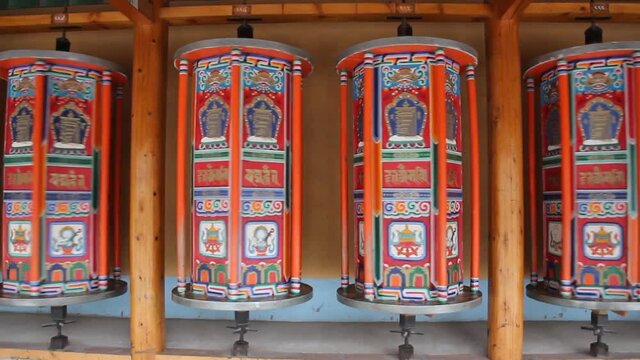 Row of praying wheels around Labrang Monastery in Xiahe town, Gansu province, China