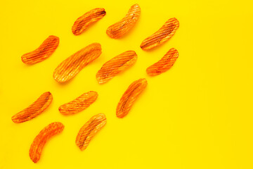 Spicy snack, Banana slice chips paprika flavor on yellow background.