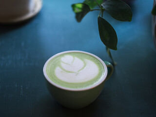 Obraz na płótnie Canvas A cup of green matcha latte tea on the table, latte art
