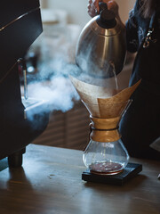 Professional barista a young woman prepares coffee in kemex, a method of making espresso