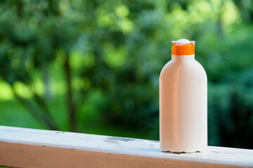 sunscreen. Empty cream packaging template on greenery background.