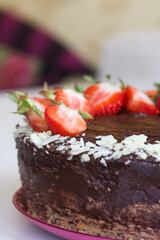 Chocolate cake with peanuts and strawberries. The process of making a cake. Close-up shot.