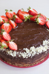 Chocolate cake with peanuts and strawberries. The process of making a cake. Close-up shot.