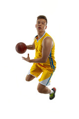 High angle view of young man, basketball player with a ball training isolated on white studio background. Advertising concept. Fit Caucasian athlete jumping with ball.