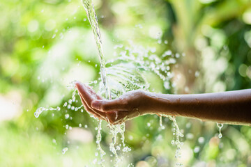 water pouring flow on woman hand on nature background - Powered by Adobe