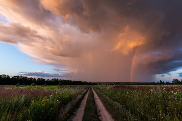 Fototapeta na wymiar Storm clouds with a rainbow before sunset