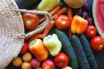 Straw bag and various seasonal fruit and vegetable. Flat lay.