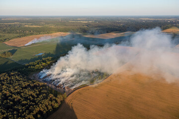 Burning litter, rubbish on a trash dump. Cloud of smoke polluting the air