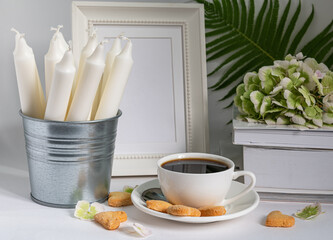 flowers, candles and a cup of coffee on a white background