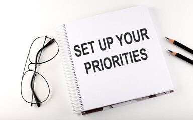 Notepad with text Set up your priorities. White background. Business